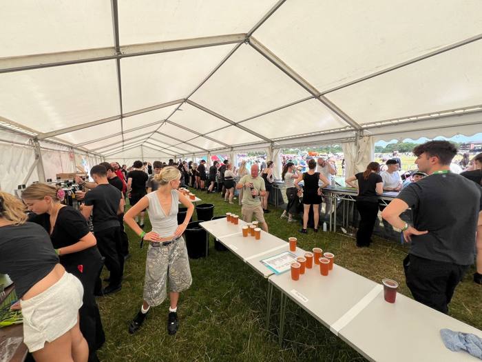 Busy bar marquee with pints lined up on the counter